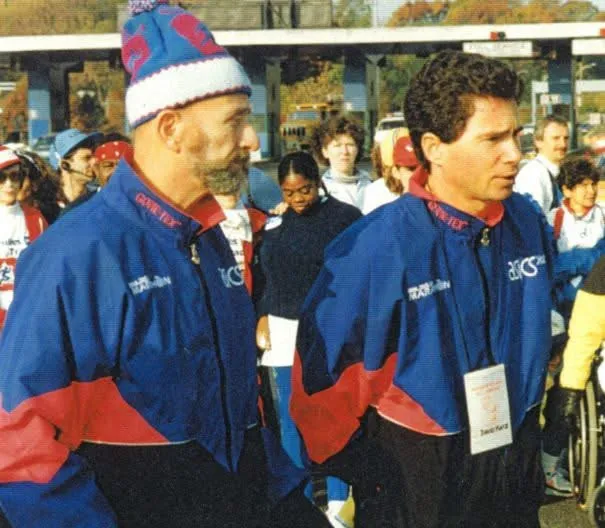 An archival photo of two race officials in team jackets.