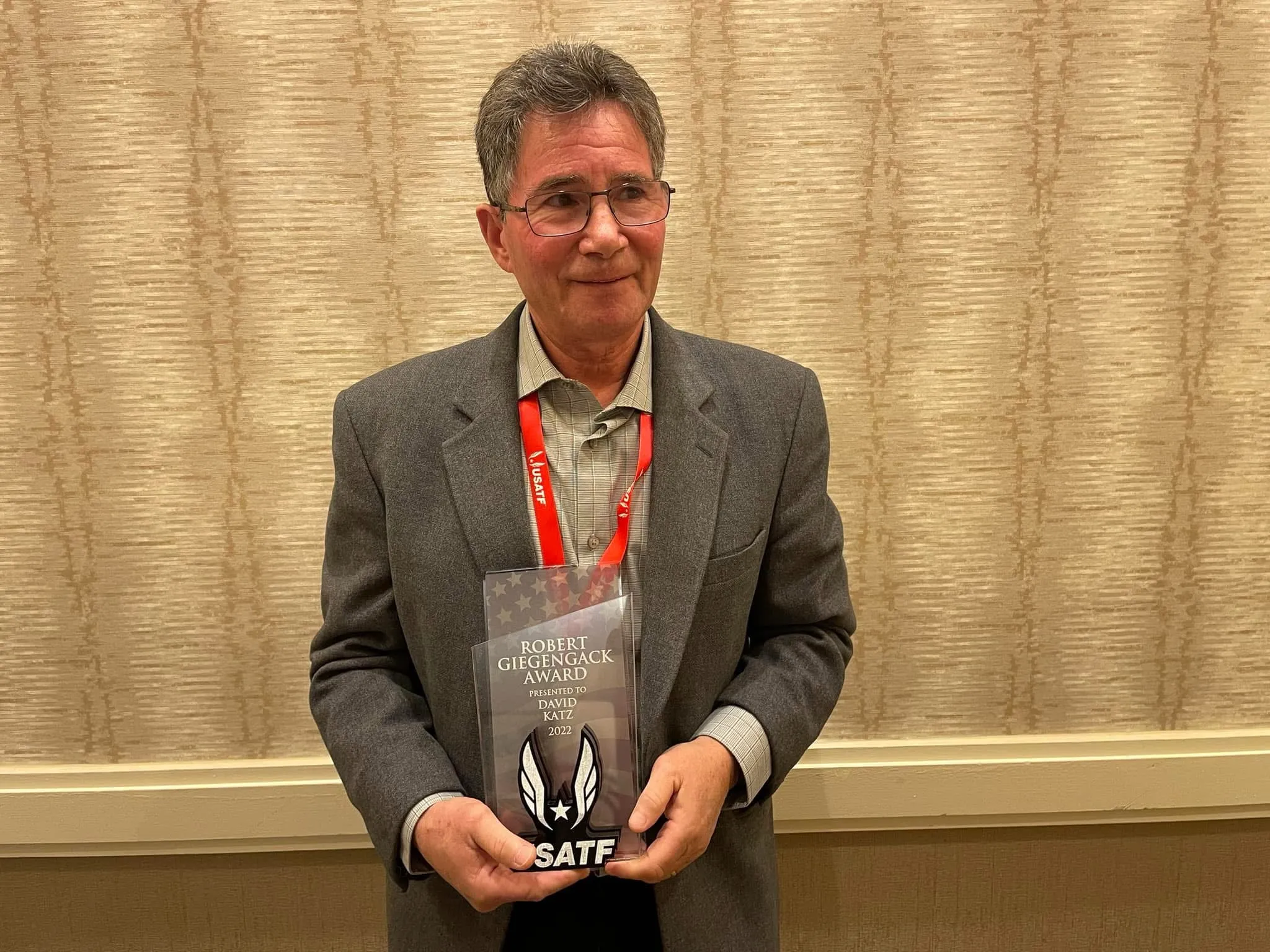 David Katz holding the USATF Robert Giegengack Award.