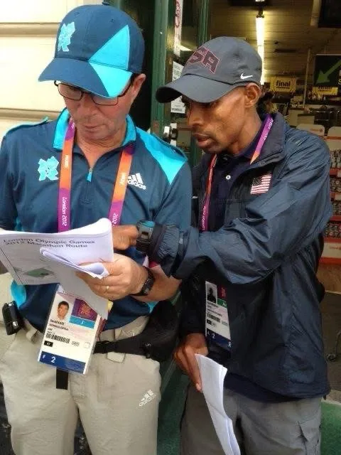 Two officials in London 2012 credentials reviewing a course document.