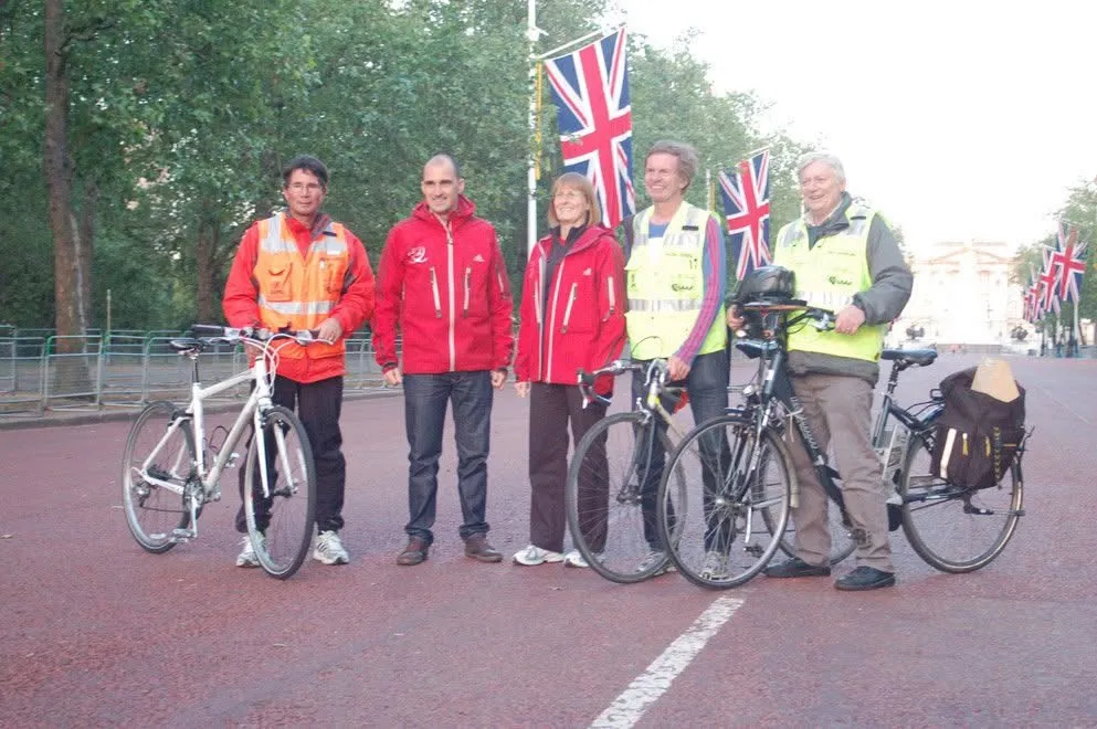 Five measurers with bicycles on The Mall in London.