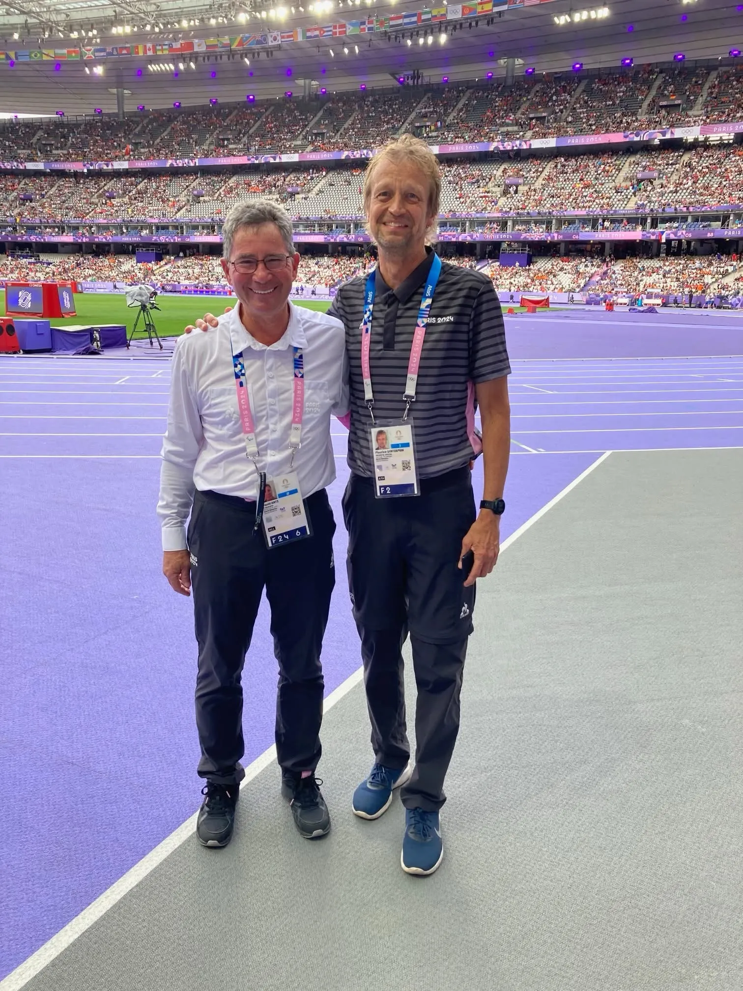 Two officials on the purple track inside the Olympic stadium.