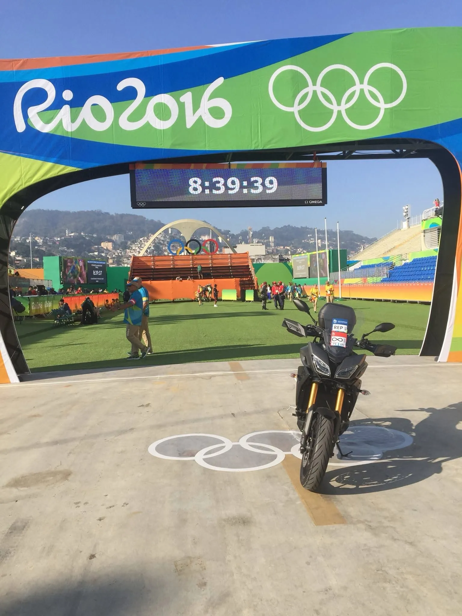 The Rio 2016 finish arch with the race clock and a lead motorcycle.